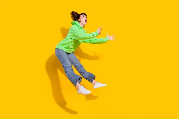 노란색 고립된 공간을 뛰어오르는 스러운 소녀의 몸길이 — 스톡 사진