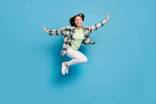 Full body profile side photo of young cheerful girl happy positive smile fly air jump isolated over blue color background.