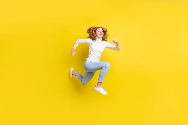 フルボディ写真の陽気な夢のような幸せな小さな女の子ジャンプアップランナー空のスペース孤立した上の黄色の色の背景 — ストック写真