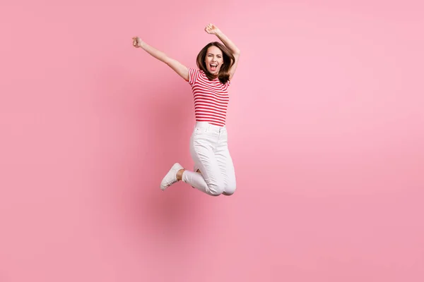 フル長いです写真の若い女の子幸せな正の笑顔持っています楽しいジャンプアップ孤立した上ピンク色の背景 — ストック写真