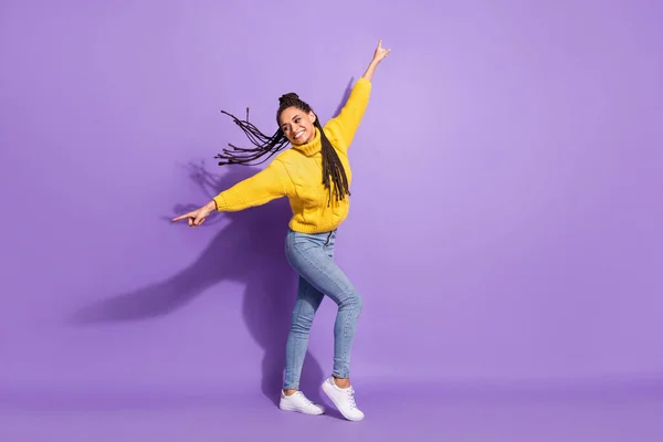 全长照片乐观有趣的黑发女孩跳舞穿毛衣牛仔裤运动鞋与紫色背景隔离 — 图库照片
