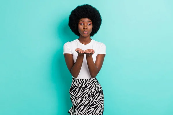 Photo of adorable happy dark skin young woman send air kiss hands you positive isolated on teal color background.