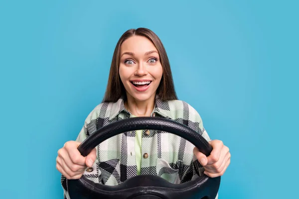 照片上年轻兴奋的女孩开心的笑着驾驶方向盘在蓝色的背景上独立行走 — 图库照片