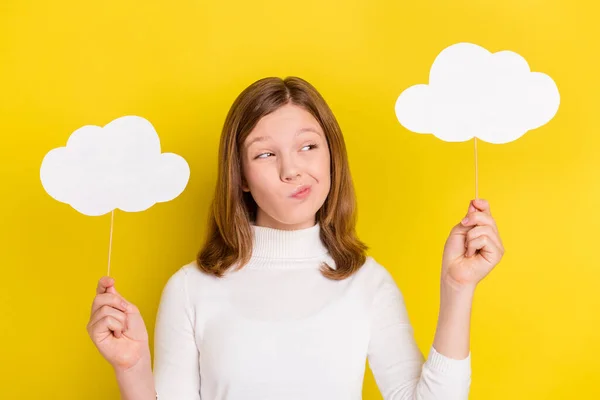 Photo of young girl uncertain unsure think hold bubble cloud stick isolated over yellow color background.