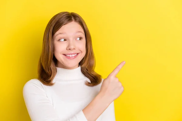 照片上漂亮的年轻快乐的小女孩看着手指空空如也的笑着隔离在黄色的背景上 — 图库照片