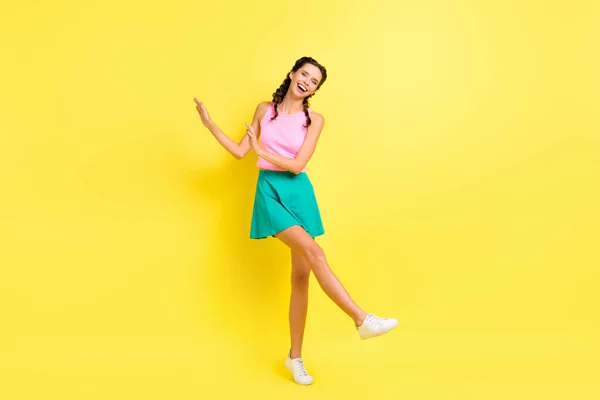 楽観的なクールなブルネットの女性のダンスのフルサイズの写真は 鮮やかな黄色の色の背景に隔離されたピンクトップブルーのスカートを着用 — ストック写真