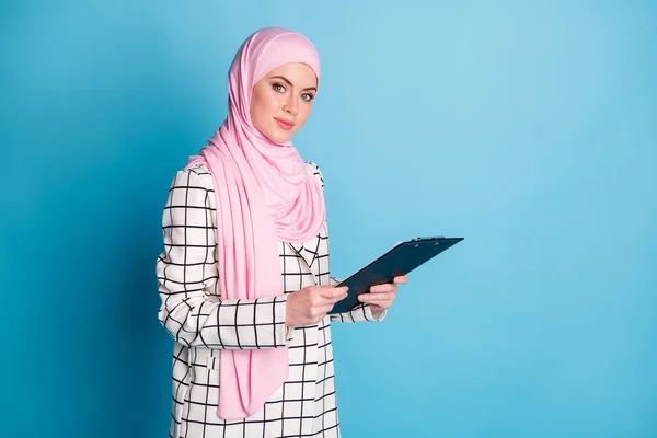 若い美しいアラビア人の少女の写真幸せな笑顔ホールドクリップボードチェックリストは 青の色の背景の上に隔離されたヒジャブを着用 — ストック写真