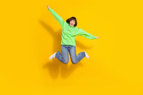 全长照片上快乐迷人的年轻女子跳起双手翅膀 与黄色背景隔离 — 图库照片