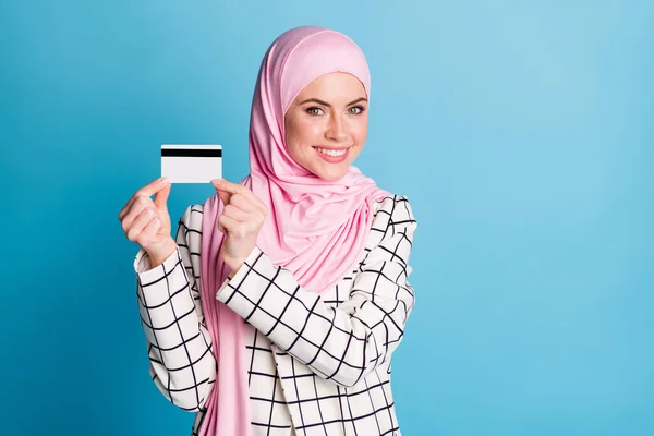 ポートレートのかなり明るいですムスリマ女の子保持で手銀行カードフリーランス絶縁上の明るい青の色の背景 — ストック写真