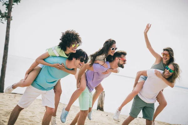 喜びに満ちた陽気な友達の写真ピギーバックライド屋外で砂のビーチをぶら下げてお楽しみください — ストック写真