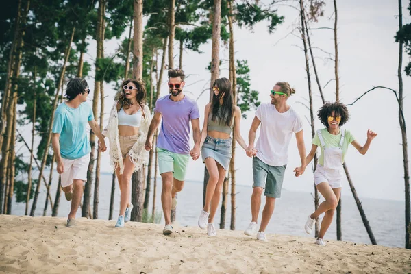 Photo of sweet pretty young people wear casual clothes holding arms enjoying walk outside countryside.