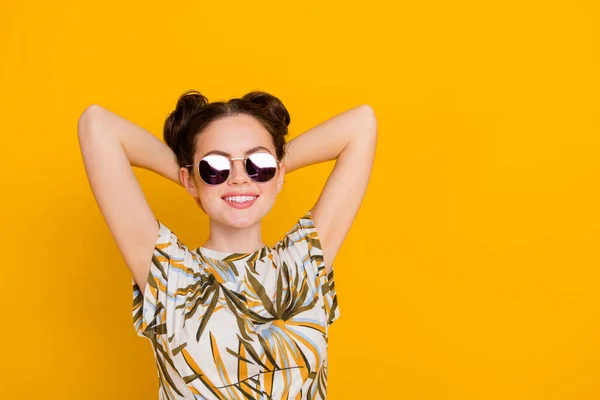 Photo of shiny dreamy lady dressed print t-shirt dark glasses arms behind head empty space isolated yellow color background.