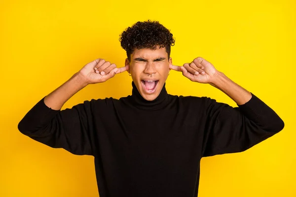 Photo of stressed brunet guy cover ears yell wear black sweater isolated on vibrant yellow color background.