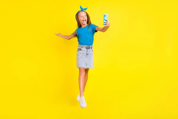 フルサイズ写真の興奮した小さな女の子ジャンプホールド電話作る自画撮り写真ビデオコール孤立した上黄色の色の背景 — ストック写真