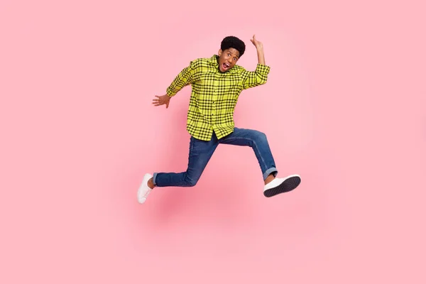全长照片 年轻时髦的黑发男子跳着穿衬衫牛仔裤运动鞋与粉色背景隔离 — 图库照片