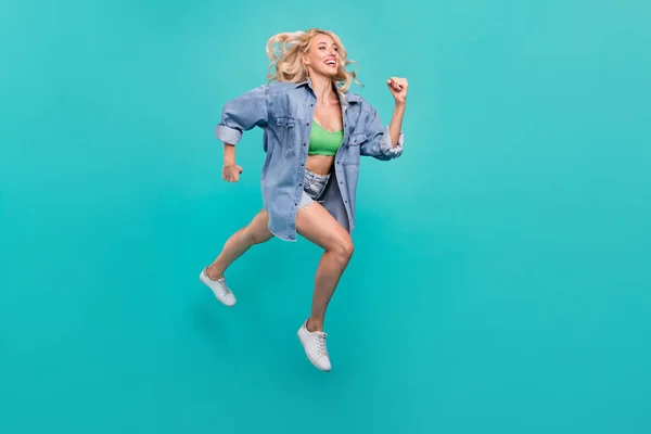 フルサイズの写真の幸せな陽気な正の女性ジャンプアップ実行空スペース隔離上の青の色の背景 — ストック写真