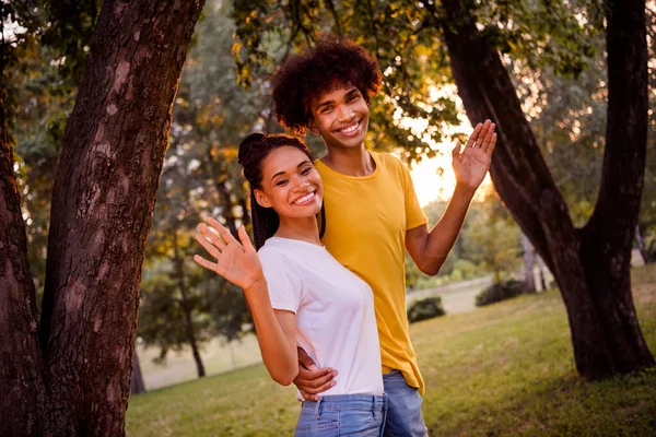プロフィールサイドビューポートレートの魅力的な陽気なカップルの友人友情手を振っハイ散歩無料時間で森の屋外 — ストック写真