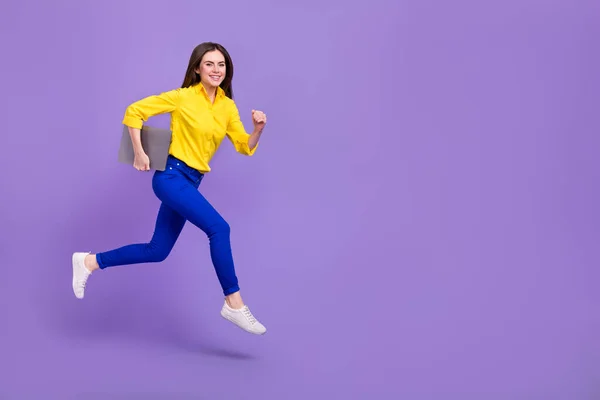Full length body size view of attractive trendy energetic girl jumping holding laptop isolated over bright violet purple color background.