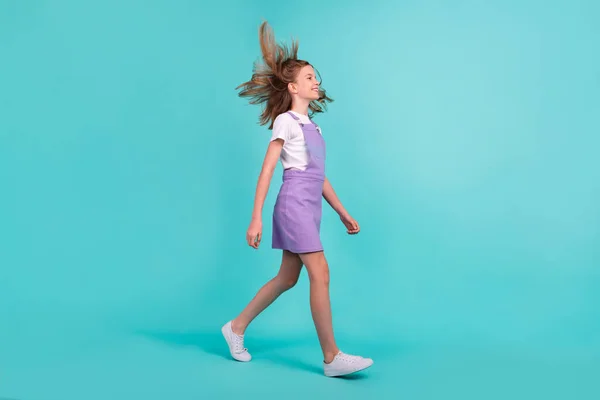 전반적 크기의 긍정적 스러운 소녀걷기 사진터는 청록색 배경에 고립된 공간으로 — 스톡 사진