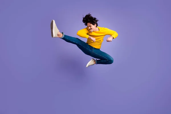 全身性照片中精力充沛的人跳腿踢腿与紫罗兰色背景隔离的复制空间 — 图库照片