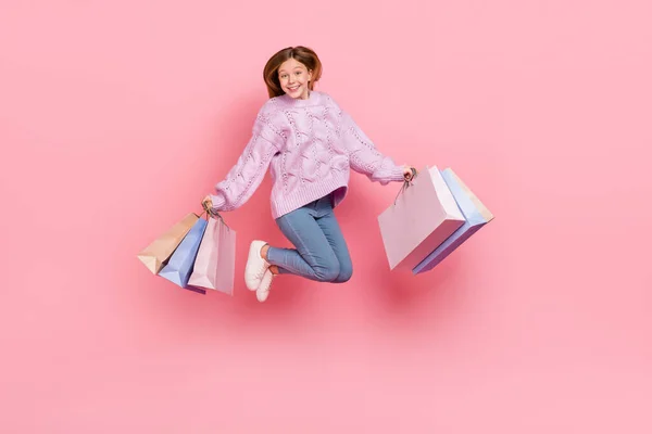 Photo Adorable Cute Girl Knitwear Sweater Holding Shopping Bags Jumping — Zdjęcie stockowe