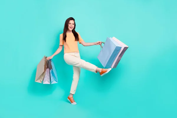Full body portrait of cheerful crazy person hold packages holiday promo isolated on teal color background.