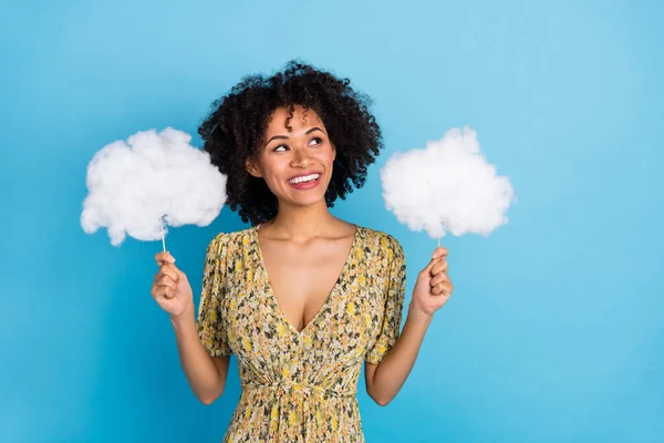 Portrait of attractive cheerful girl holding in hands clouds think copy space isolated over bright blue color background.