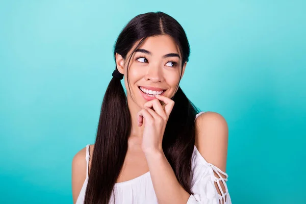 Photo of sweet charming lady wear white top looking empty space finger mouth isolated turquoise color background.