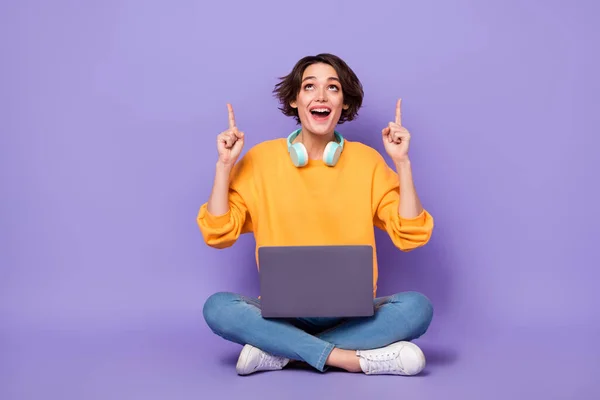 Full size portrait of attractive excited person look direct fingers up empty space isolated on purple color background.
