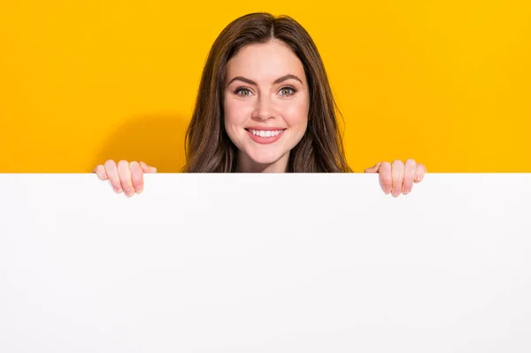Portrait Positive Nice Girl Hiding Empty Space Board Isolated Yellow — kuvapankkivalokuva