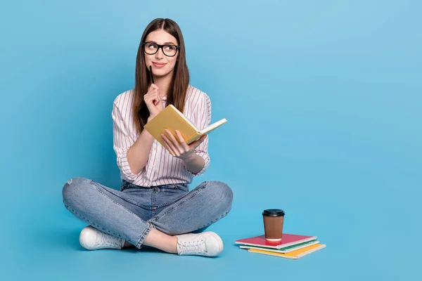 Portrait of beautiful trendy minded girl sitting doing homework idea task isolated over bright blue color background.