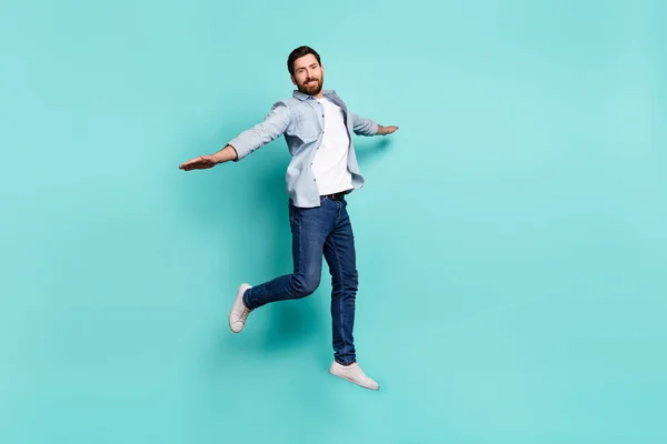 Full body portrait of active sporty person raise hands flying jumping isolated on teal color background.