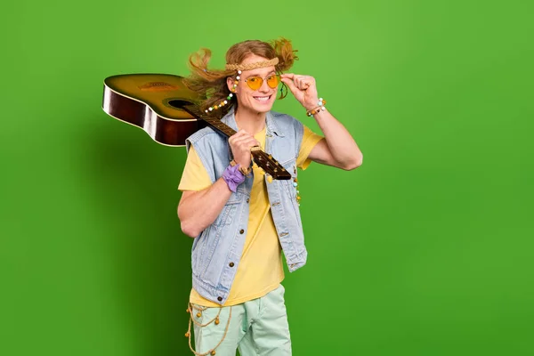 Photo of youngster guy wander musician hold guitar wear denim stylish jeans vest isolated bright color background.