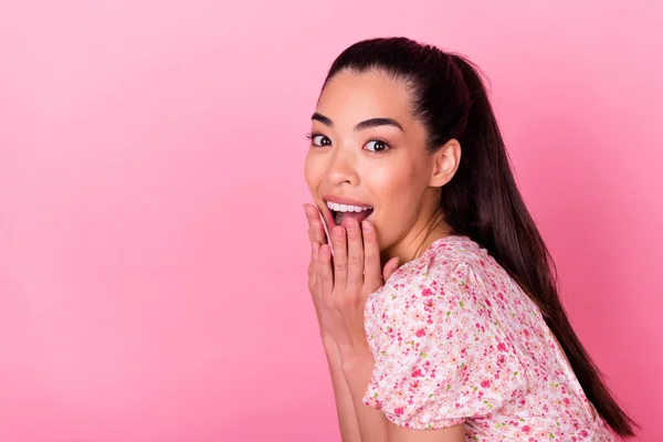 Profile portrait of impressed cheerful person hands cover mouth empty space isolated on pink color background.