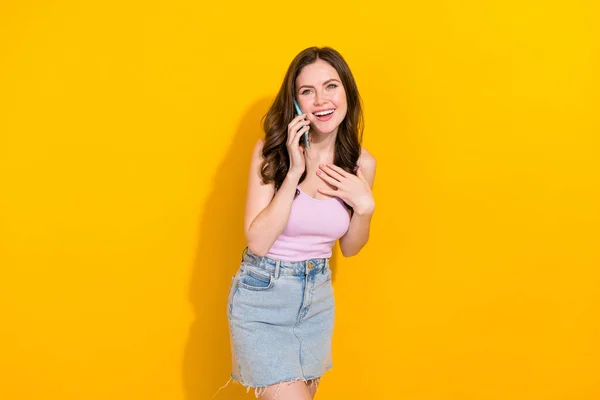 Photo of positive funky lady speak communicate telephone laugh isolated on yellow color background.