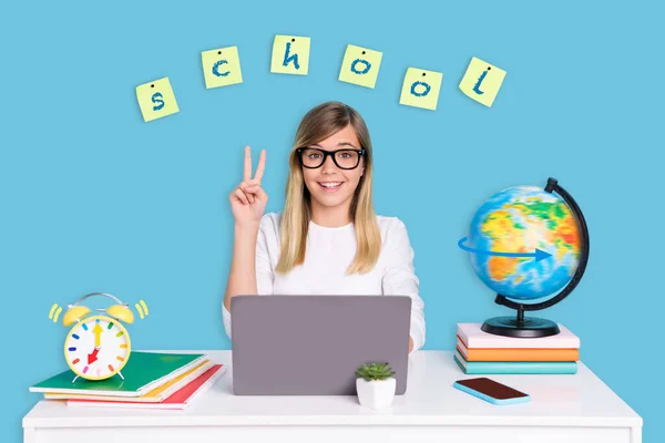 Magazine collage of clever little woman elearning use netbook make v sign sit table isolated on blue color background.