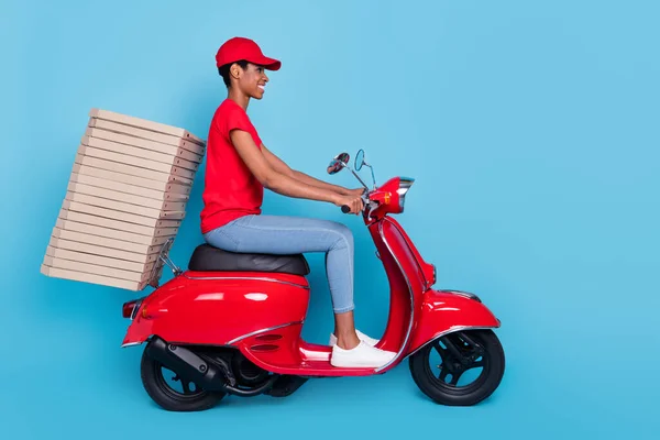Photo of cheerful pretty short hair person dressed red uniform moto rider delivering pizzas stack isolated blue color background.