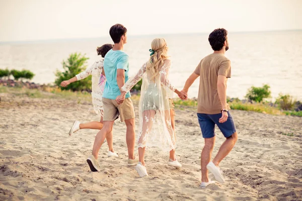 Photo Cheerful Positive Buddies Company Walking Holding Hands Smiling Outdoors — Stockfoto