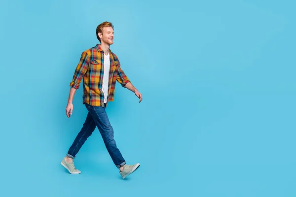 Full length photo of handsome man with ginger hair dressed stylish plaid shirt go shopping big sale isolated on blue color background.