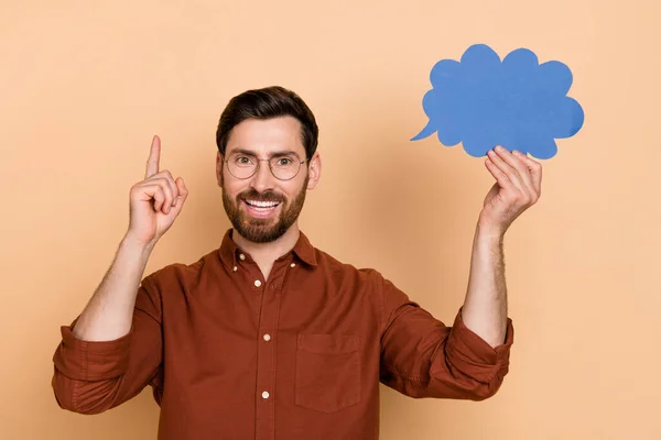 Photo of intelligent excited person point finger hold cloud paper card isolated on beige color background.