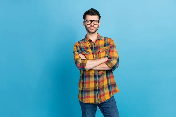 Photo of clever handsome confident businessman in eyeglasses dressed checkered shirt arms crossed isolated on blue color background.