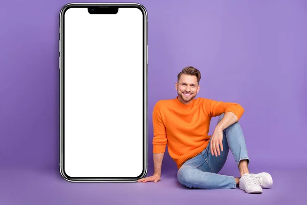 Photo Cheerful Man Sitting Next Modern Technology Telephone Placard Advert — Stockfoto