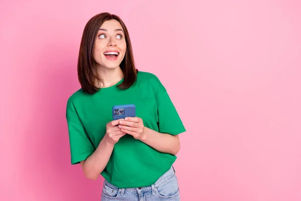 Portrait of cheerful funky girl hold telephone look empty space offer isolated on pink color background.