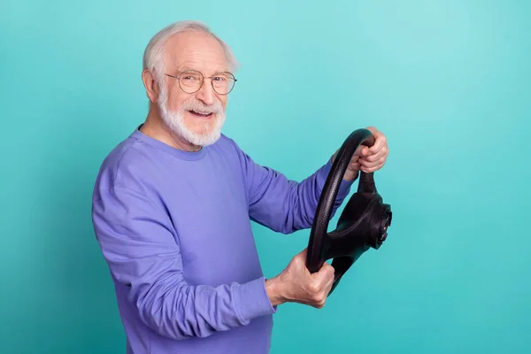 Profile photo of cheerful aged person arms hold wheel toothy smile isolated on turquoise color background.