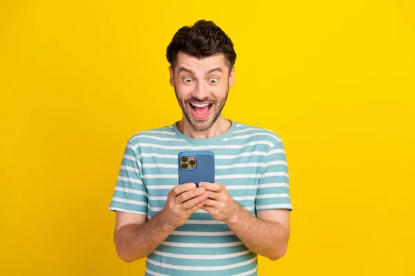Photo Funny Ecstatic Handsome Guy Dressed Striped Shirt Look Smartphone —  Fotos de Stock