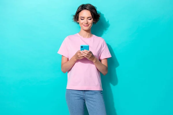 Photo of funky bob hair young lady look telephone wear pink t-shirt jeans isolated on turquoise color background.