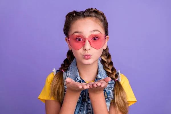 Photo of flirty school blond girl blow kiss wear eyewear t-shirt jeans vest isolated on violet color background.