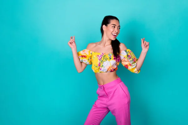 Photo of funky millennial lady dance look empty space wear floral top pink pants isolated on teal color background.