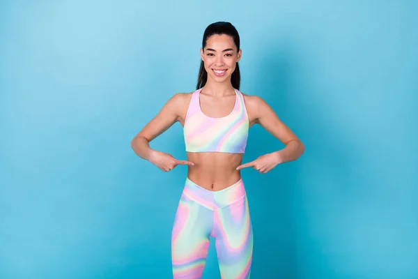 Photo slender lady trainer point belly muscular body wear rainbow print top leggings pants isolated blue color background.