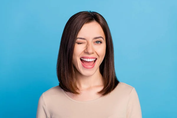 Portrait of overjoyed satisfied lady eye wink beaming smile isolated on blue color background.